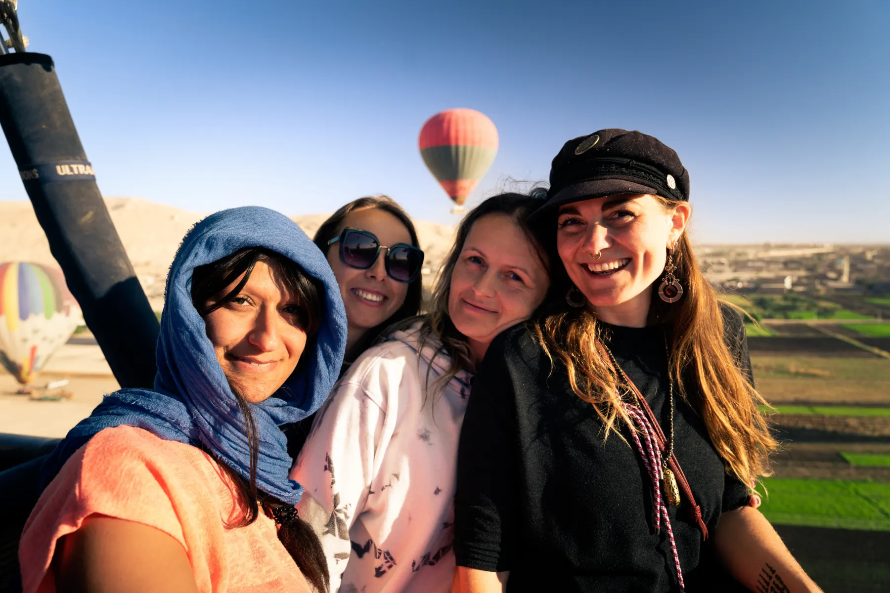 Vrouwen maken een selfie met luchtballonnen boven het Egyptische landschap
