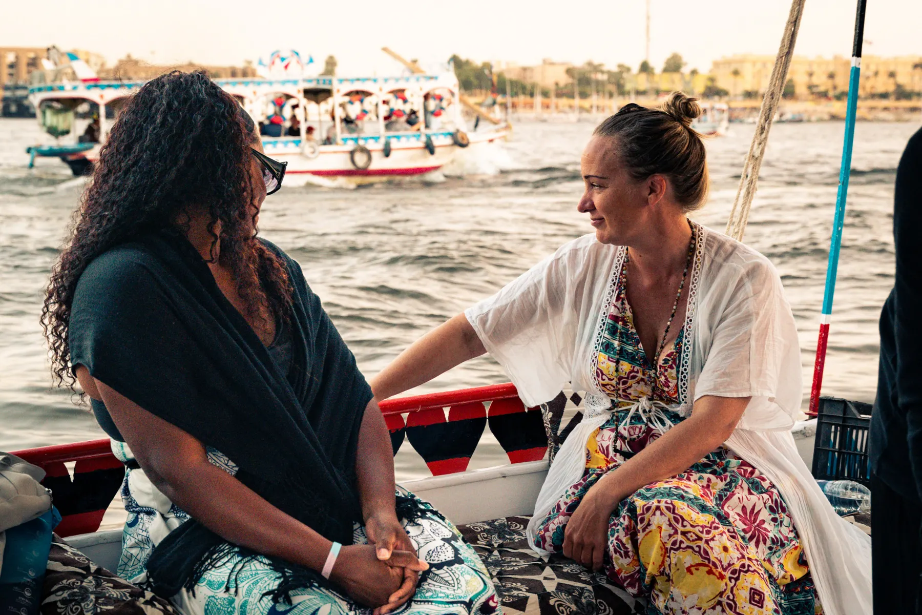 Twee vrouwen in gesprek op een boot op de rivier, Egypte