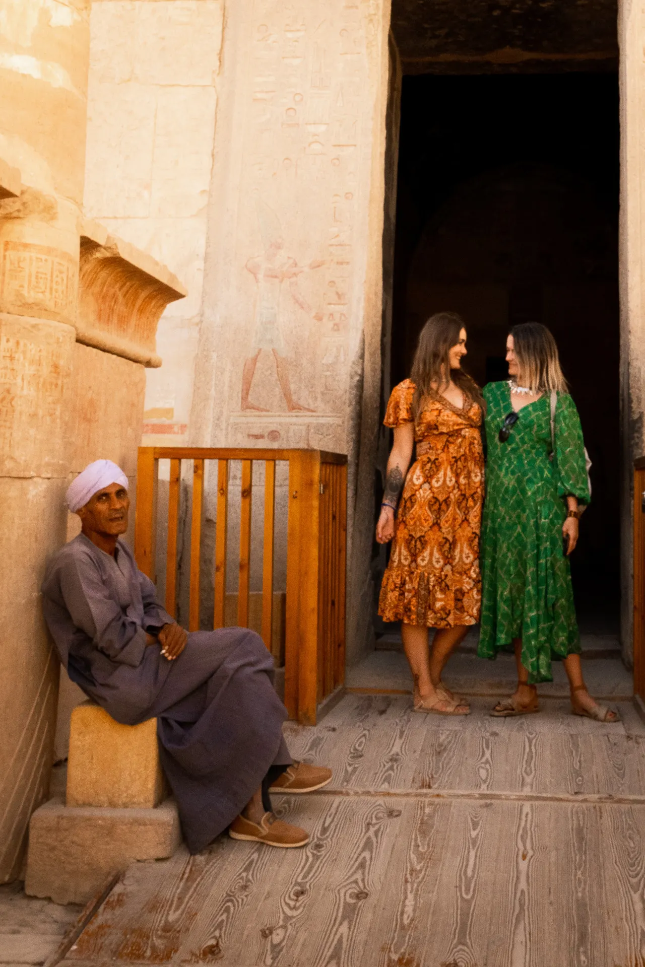 Twee vrouwen in kleurrijke jurken in een tempeldeur, Egypte