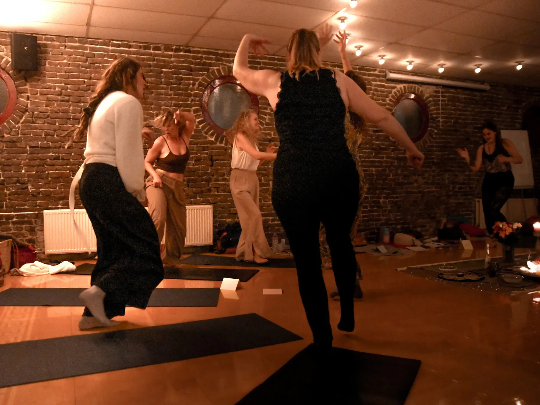 Vrouwen dansen vrij op blote voeten in een zaal met lichtslingers