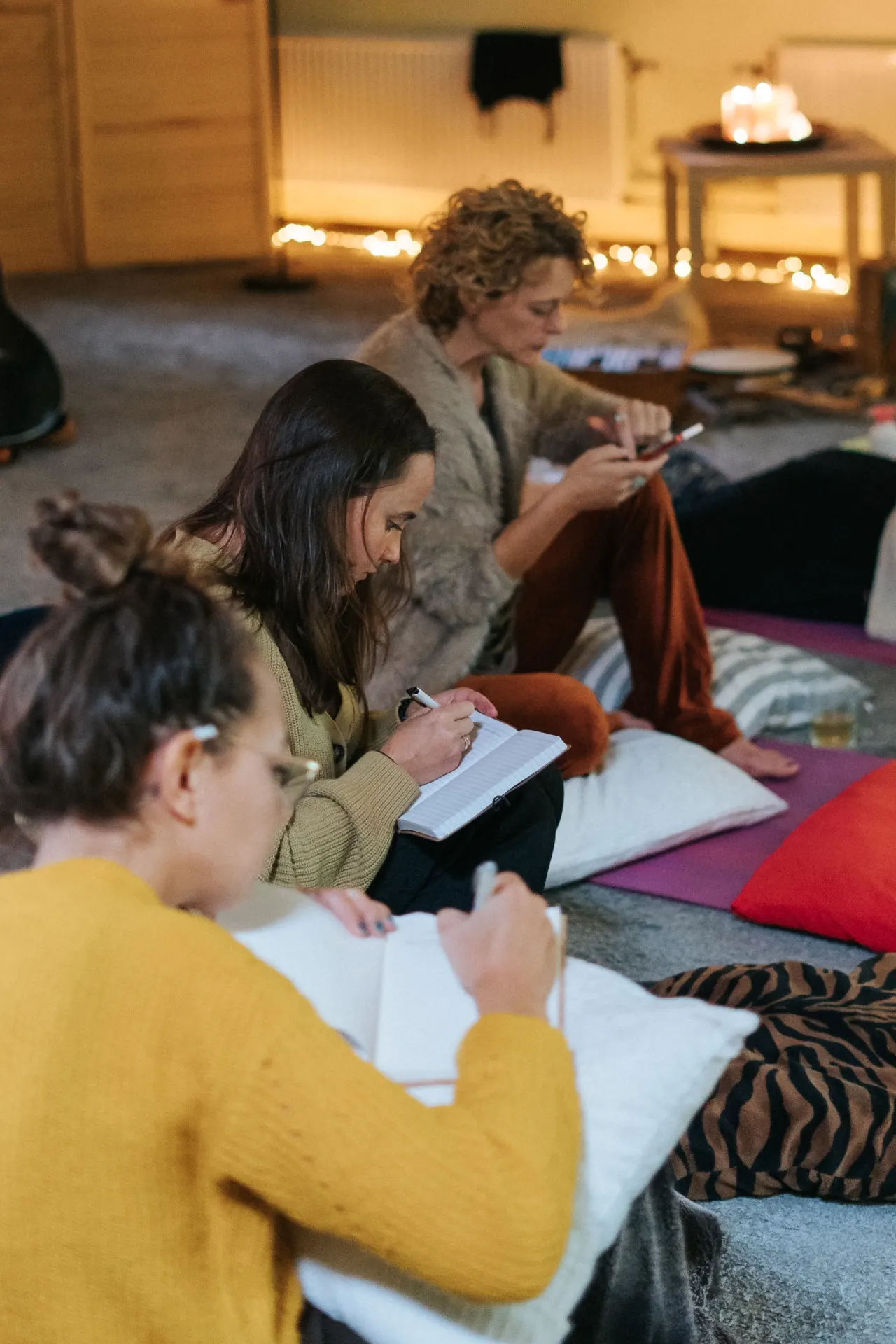 Women writing in their journals on cushions in the circle room
