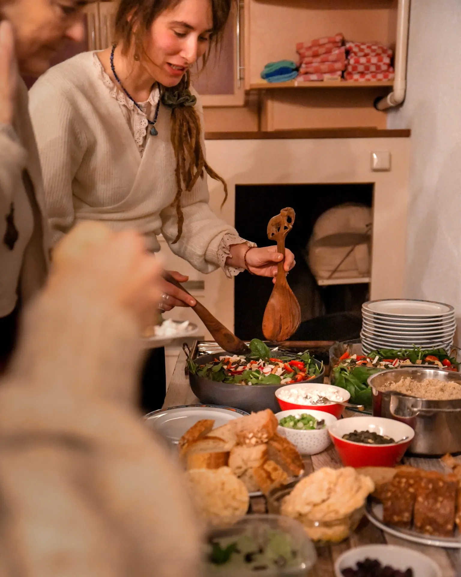 Gedeelde maaltijd: een vrouw schept op aan een tafel vol eten