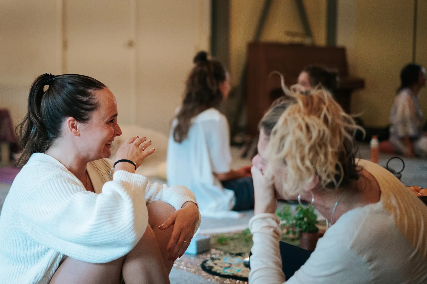 Vrouwen delen lachend hun verhalen in de cirkel