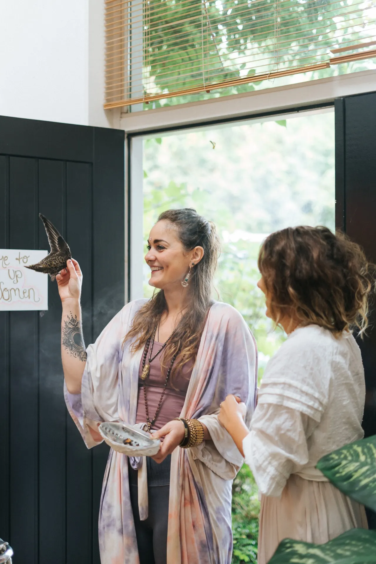 A warm welcome at the door of the circle room, feather in hand